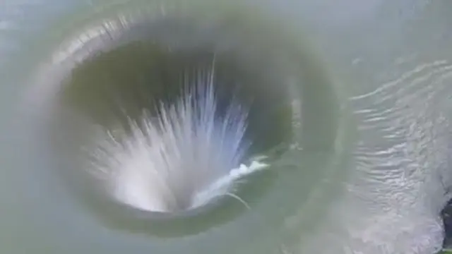 Screenshot dari clip video, yang menunjukan deras air yang mengalir ke lubang misterius (express.co.uk)