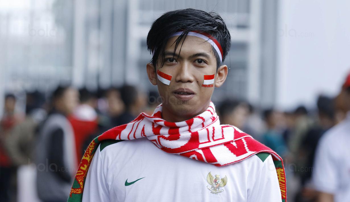 Suporter asal Karawang, Andri, bepose di SUGBK, Senayan, Jakarta, Minggu (14/1/2018). Selain untuk menyaksikan laga Indonesia Vs Islandia, kehadiran para suporter juga karena ingit melihat wajah baru SUGBK. (Bola.com/M Iqbal Ichsan)