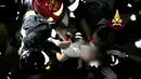 Petugas saat mengevakuasi bayi setelah gempa melanda pulau wisata di Ischia, di lepas pantai Napoli, Italia (21/8). Akibat gempa tersebut dua orang tewas . (AFP Photo/Vigili del Fuoco)