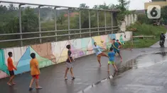 Anak-anak bermain sepak bola di sekitar kawasan Depok, Jawa Barat, Kamis (16/4/2020). Kurangnya sanksi tegas membuat sebagian warga Depok bebas berkeliaran untuk bersosialisasi, meskipun saat ini sedang diberlakukan PSBB untuk mencegah penyebaran Covid-19. (Liputan6.com/Immanuel Antonius)