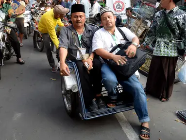 Peserta Muktamar NU menaiki Bentor (Becak Motor) dikawasan Alun - Alun Kota, Jombang, Jawa Timur, Rabu (5/8/2015). Becak motor menjadi Kendaraan pilihan para peserta Muktamar NU untuk keliling Kota Jombang. (Liputan6.com/JohanTallo)