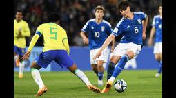 Pemain Timnas Italia U-20, Cesare Casadei (kanan), berusaha melewati hadangan pemain Timnas Brasil U-20, Andrey Santos (kiri) dalam pertandingan Grup D Piala Dunia U-20 2023 yang berlangsung di Malvinas Argentinas stadium, Argentina, Minggu (21/5/2023). Casedei yang dipinjamkan Chelsea ke Reading pada musim 2022/2023 telah mendulang enam gol dan satu assist dalam 28 laga yang ia mainkan di semua kompetisi. (AFP/Andres Larrovere)