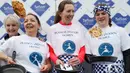 Katie Godof (tengah) berpose setelah memenangkan lomba lari sembari membawa wajan berisi pancake di Olney, Buckinghamshire, Inggris, Selasa (25/2/2020). Para peserta kompetisi tahunan tersebut harus membolak-balikan pancake sambil tetap berlari. (AP/Alastair Grant)