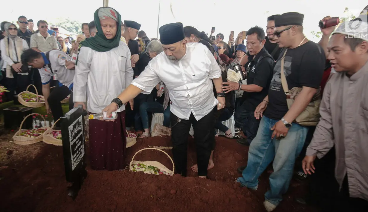 Komedian Indro Warkop menyiramkan air di pusara istrinya, Nita Octobijanthy di TPU Tanah Kusir, Jakarta, Rabu (10/10). Nita mengembuskan napas terakhir pada Selasa, 9 Oktober 2018 malam. (Liputan6.com/Faizal Fanani)