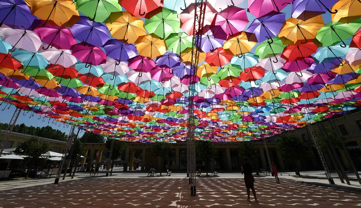 Penampakan instalasi Umbrella Sky Project di Aix-en-Provence, Prancis, Jumat (28/6/2019). Spot berteduh yang instagramable tersebut merupakan karya seniman Portugis Patricia Cunha. (BORIS HORVAT/AFP)