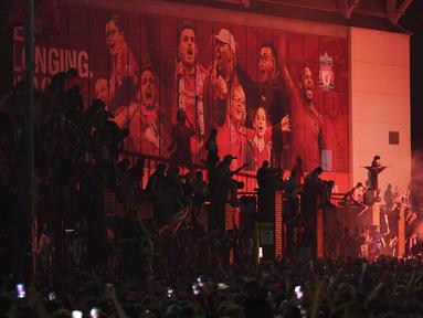 Suporter Liverpool merayakan gelar juara Premier League di depan Stadion Anfield, Kamis (25/6/2020). Titel juara Liga Inggris 2019-20 ini merupakan gelar pertama Liverpool setelah puasa selama 30 tahun. (AP/Jon Super)