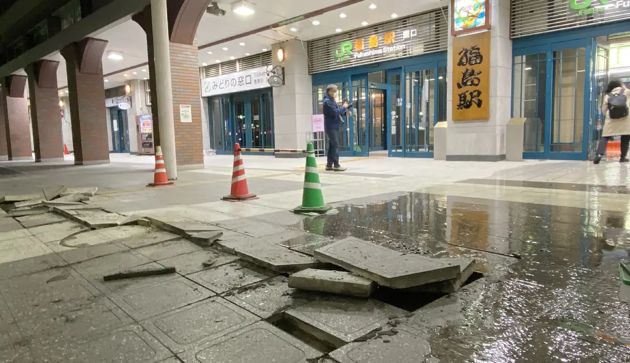 Blok trotoar yang rusak di tanah di depan Stasiun JR Fukushima, yang tampaknya telah retak akibat dampak gempa di Fukushima, Jepang (17/3/2022). Gempa kuat Magnitudo 7,3 mengguncang lepas pantai Fukushima di Jepang utara pada hari Rabu (16/3), memicu peringatan tsunami. (AFP/STR/Jiji Press)