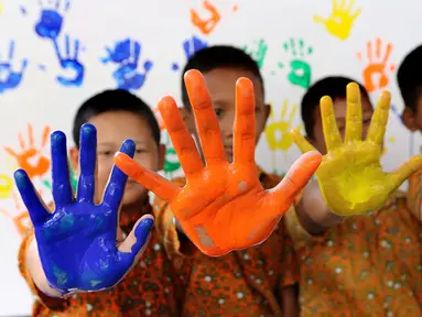 Empat siswa menunjukkan tangan berlumuran cat air di SD Negeri 15 Karet Tengsin, Jakarta, Rabu (18/10). Kegiatan yang diadakan operator penyedia air Palyja digelar dalam rangka Hari Cuci Tangan Pakai Sabun Sedunia. (Liputan6.com/Fery Pradolo)
