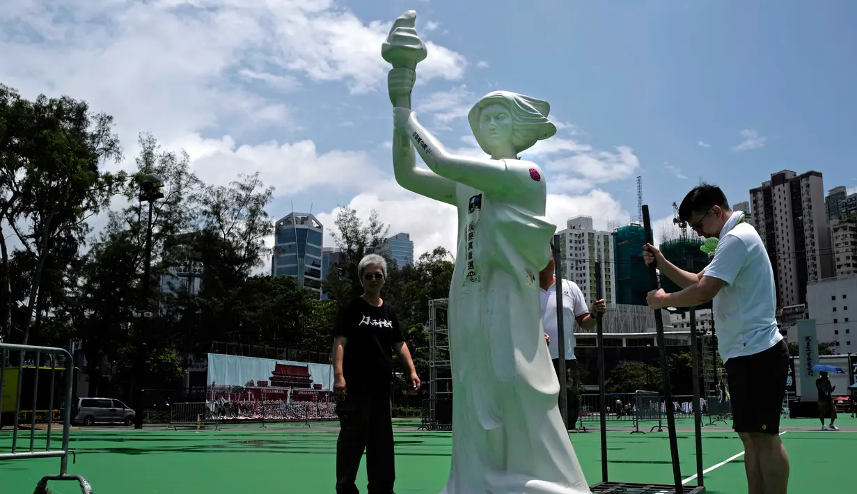 Patung Dewi Demokrasi didirikan di Taman Victoria Hong Kong (4/6/2019). Puluhan ribu orang diperkirakan akan menghadiri acara nyala lilin tahunan untuk para korban penindasan militer pemerintah China tiga dekade lalu terhadap para pengunjuk rasa di Beijing. Lapangan Tiananmen. (AP Photo/Vincent Yu)