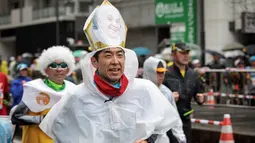 Seorang peserta mengenakan topi bergambar Paus Fransiskus selama mengikuti ajang Tokyo Marathon 2019 di Jepang, Minggu (3/3). Sebagian peserta tampil dengan mengenakan kostum unik seperti tokoh kartun. (AFP Photo/Behrouz Mehri)