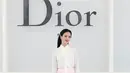Jisoo tampil manis dengan blus putih berpita di leher dan rok tulle ruffle pink menggelembung. Clutch berbentuk angsa dan heels pita peach berhias bunga. [dok. Dior]
