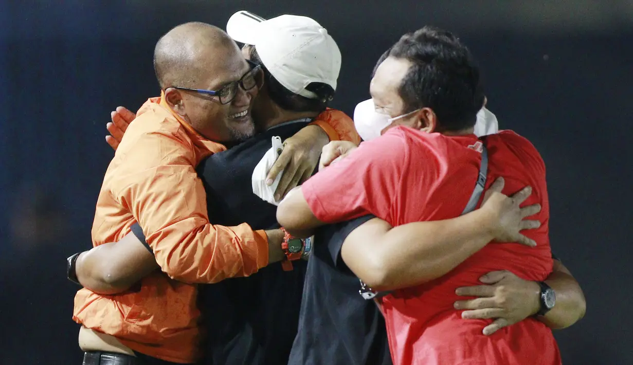 Pelatih Persija Jakarta, Sudirman, berpelukan dengan para staf pelatih usai menjuarai Piala Menpora 2021 di Stadion Manahan, Solo, Minggu (25/4/2021). (Bola.com/M Iqbal Ichsan)