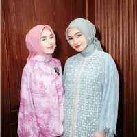 Beby Tsabina tampil dalam nuansa warna pink yang lembut dan feminin. Tunik bermotif floral dengan desain longgar yang dipadukan dengan rok maxi berpotongan flowy memberikan kesan anggun dan klasik. [@caitlinhalderman/@bebytsabina].