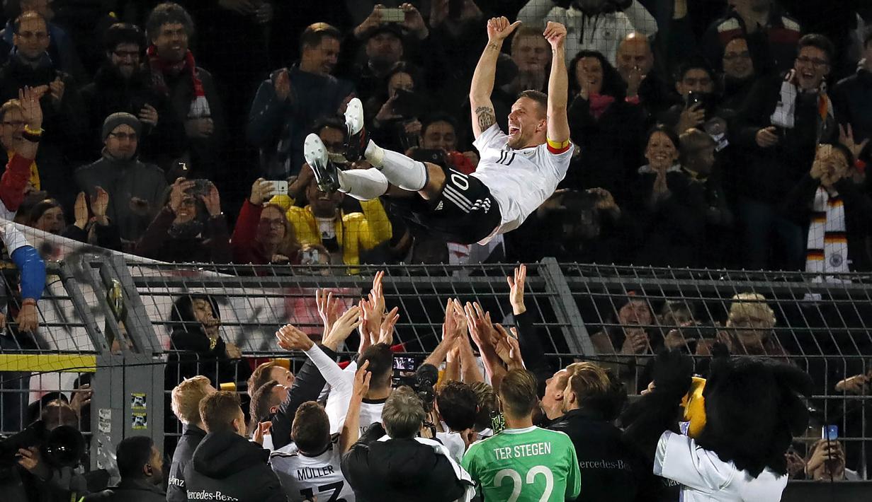 Gelandang Jerman, Lukas Podolski, melakukan selebrasi bersama rekan senegaranya. Di laga terakhirnya bersama Jerman, Podolski, berhasil mencetak gol kemenangan atas Inggris. (EPA/Ronald Wittek)