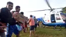 Warga gotong royong menurunkan barang dari helikopter PMI saat pendistribusian bantuan untuk korban banjir bandang dan longsor di Desa Cileuksa, Sukajaya, Bogor, Senin (6/1/2019). PMI mengerahkan helikopter lantaran lokasi bencana tidak bisa dijangkau melalui jalur darat. (Liputan6.com/Tim Media JK)