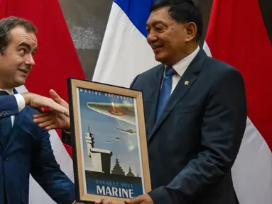 Menteri Pertahanan Republik Indonesia, Sjafrie Sjamsoeddin (kanan) menerima cinderamata dari Menhan Prancis, Sebastian Lecornu, dalam pertemuan mereka di Gedung Kementerian Pertahanan (Kemenhan), Jalan Medan Merdeka Barat, Jakarta Pusat, Jumat (31/1/2025). (ADITYA AJI/AFP)