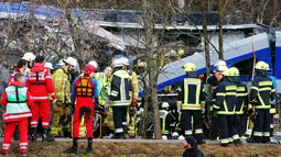Regu penyelamat berusaha mengevakuasi korban tabrakan antara dua kereta di dekat Bad Aibling, Jerman, Selasa (9/2). Beberapa penumpang dilaporkan masih terjebak di dalam puing-puing gerbong. (REUTERS/Michael Dalder)