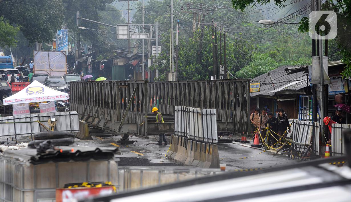 Aktivitas pekerja di Jembatan Cikreteg yang longsor di akses jalan nasional Bogor-Sukabumi, Caringin, Kabupaten Bogor, Jawa Barat, Kamis (2/3/2023). Ruas jalan Jembatan Cikereteg longsor pada Senin (27/2/2023) pukul 11.00 WIB akibat tingginya intensitas hujan di wilayah tersebut sehingga semua arus lalu lintas kendaraan menuju ke lokasi itu ditutup total dan kendaraan roda empat dialihkan lewat jalan tol. (merdeka.com/Arie Basuki)