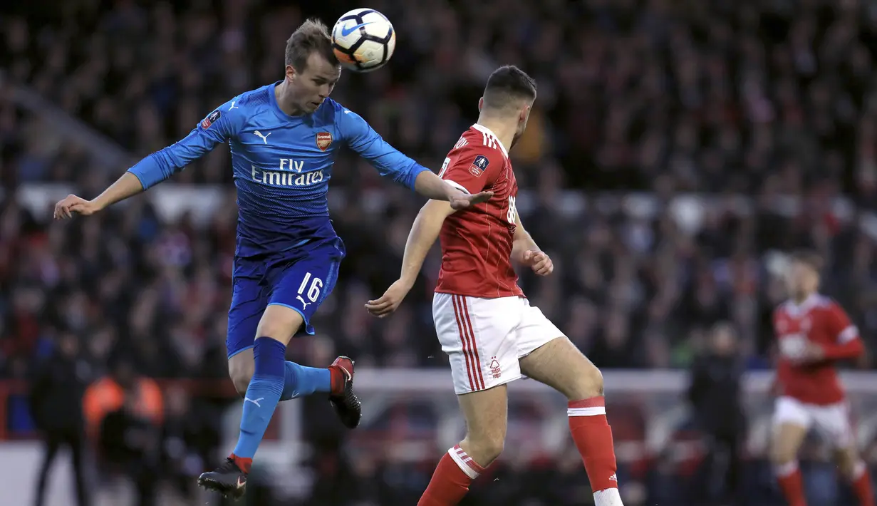 Bek Arsenal, Rob Holding, duel udara dengan pemain Nottingham Forest, Ben Brereton, pada laga Piala FA di Stadion City Ground, Minggu (7/1/2018). Arsenal takluk 2-4 dari Nottingham Forest. (AP/Mike Egerton)