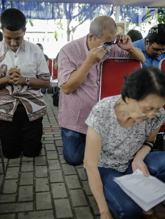 Sejumlah jemaat berdoa sambil menangis saat menyaksikan prosesi jalan salib di Gereja Katedral, Jakarta, Jumat (30/3). Prosesi di antaranya ketika Yesus disalibkan, wafat, lalu dimakamkan. (Liputan6.com/Faizal Fanani)