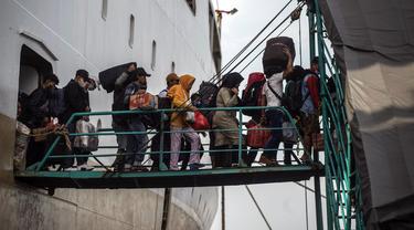 Penumpang turun dari kapal di pelabuhan di Surabaya, Jawa Timur, Kamis (28/4/2022). Orang-orang melakukan perjalanan ke kota asalnya menjelang Idul Fitri yang menandai berakhirnya bulan suci Ramadhan. (Juni Kriswanto/AFP)