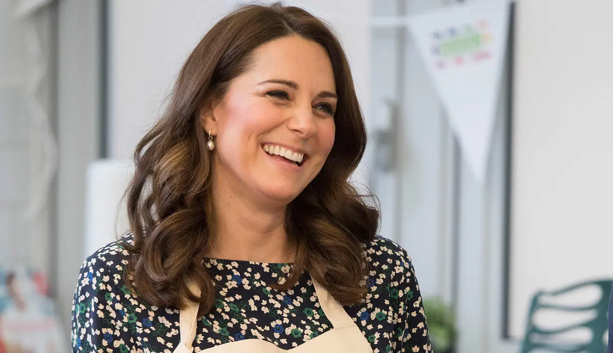 Kate Middleton tersenyum saat memasak dalam persiapan acara Commonwealth Big Lunch di Luke's Community Centre, London, Inggris (22/3). Big Lunch merupakan acara tahunan terbesar di Inggris. (Paul Edwards/ Pool via AP)