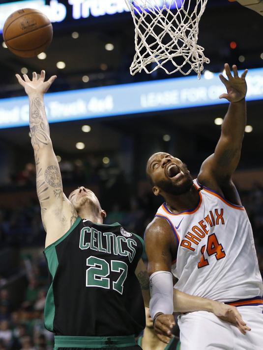 Pebasket Boston Celtics, Daniel Theis, berebut bola dengan pebasket Phoenix Suns, Greg Monroe, pada laga NBA di Stadion TD Garden, Boston Minggu (3/12/2017). Boston Celtics menang 116-111 atas Phoenix Suns. (AP/Michael Dwyer)