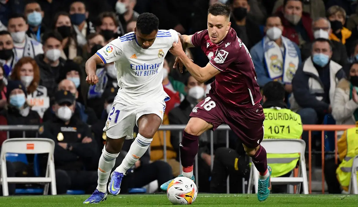Pemain Real Madrid Rodrygo (kiri) berebut bola dengan pemain Real Sociedad Andoni Gorosabel pada pertandingan sepak bola Liga Spanyol di Stadion Santiago Bernabeu, Madrid, Spanyol, 5 Maret 2022. Real Madrid menang 4-1. (PIERRE-PHILIPPE MARCOU/AFP)