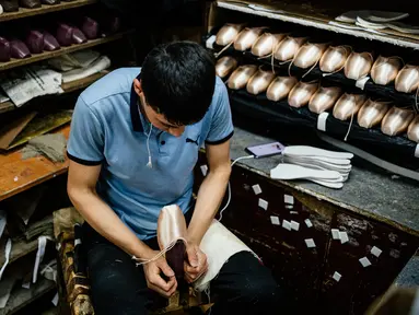 Pekerja menyelesaikan pembuatan sepatu pointe di bengkel perusahaan Grishko, Moskow, Rusia, 25 Februari 2020. Grishko yang lahir dalam kekacauan runtuhnya Uni Soviet sekarang menjadi salah satu pembuat sepatu balet top dunia. (Dimitar DILKOFF/AFP)
