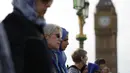 Sejumlah perempuan mengheningkan cipta di Jembatan Westminster, London, Minggu (26/3). Barisan perempuan mengenakan warna biru sebagai simbol harapan dan saling bergenggaman tangan di sepanjang jembatan tempat teror London terjadi (Daniel LEAL-OLIVAS/AFP)