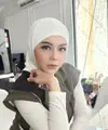 Jenita Janet tampil mengenakan kerudung putih dipadukan vest hijau dengan inner manset putihnya. Credit: Instagram (@jenitajanet)