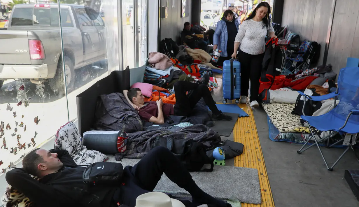 Pengungsi Ukraina menunggu untuk memasuki Amerika Serikat di Pelabuhan Masuk San Ysidro perbatasan AS-Meksiko, di Tijuana, Meksiko, pada 4 April 2022. Ratusan warga Ukraina menunggu di sebuah perkemahan di Tijuana, selatan San Diego, berharap untuk mencari suaka AS. (SANDY HUFFAKER/AFP)