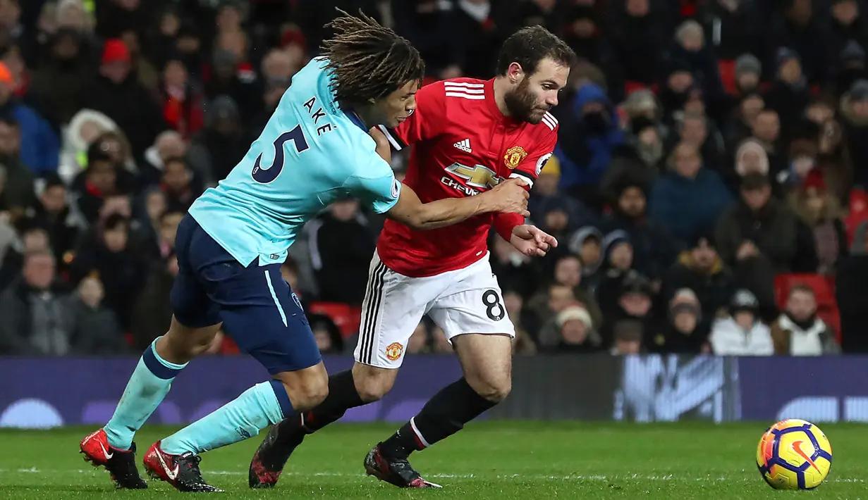 Pemain Manchester United, Juan Mata berebut bola dengan pemain AFC Bournemouth, Nathan Ake pada lanjutan laga Premier League di Old Trafford, Rabu (13/12). Manchester United unggul hanya 1-0 lewat gol Romelu Lukaku. (Martin Rickett/PA via AP)