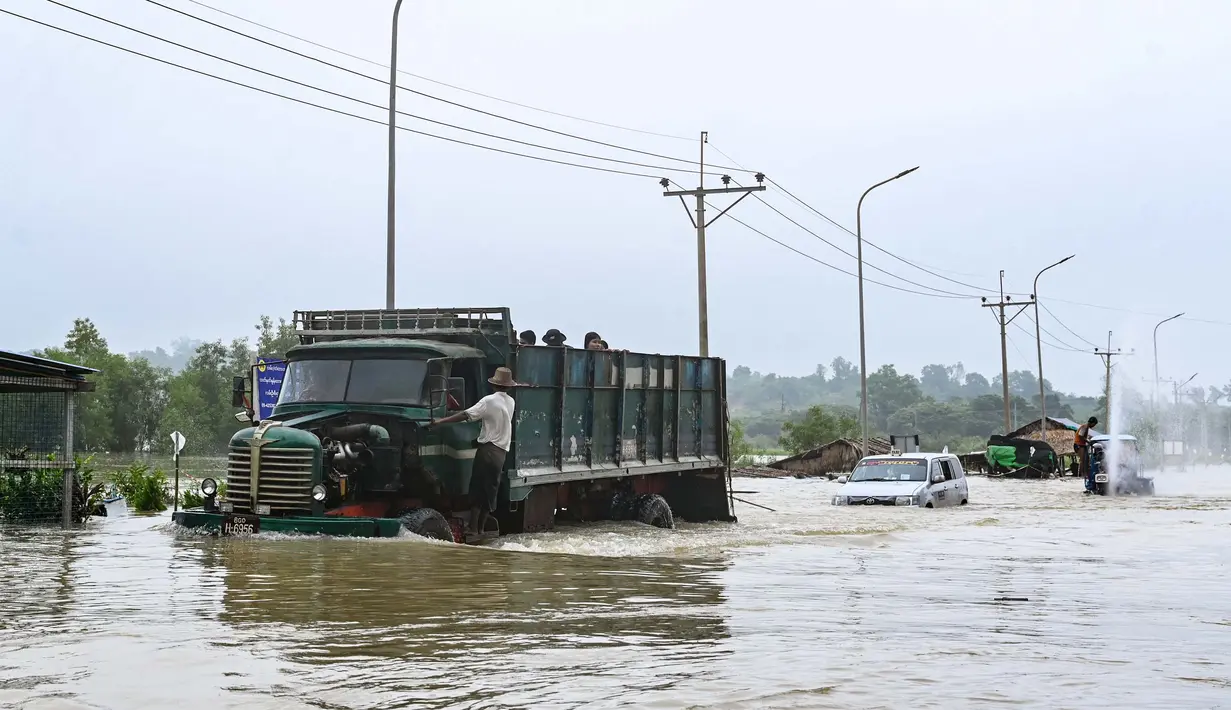 Sebuah truk melintasi jalan yang tergenang banjir di kota Hpa Yar Gyi di wilayah Bago, Myanmar, pada 9 Oktober 2023. (SAI AUNG MAIN/AFP)