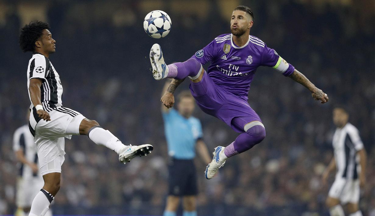Kapten Real Madrid, Sergio Ramos, mengamankan bola dari gelandang Juventus, Juan Cuadrado, pada laga final Liga Champions di Stadion Stadion Millenium, Cardiff, Sabtu (3/6/2017). Madrid menang 4-1 atas Juventus. (AFP/Adrian Dennis)