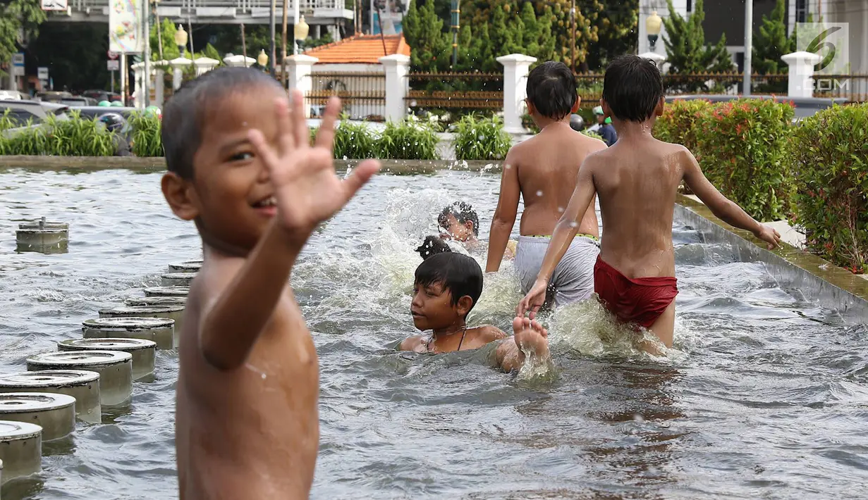 Anak-anak bermain di kolam air mancur penghias kawasan Pasar Baru, Jakarta, Selasa (29/1). Keterbatasan lahan bermain menyebabkan sebagian anak di Ibukota bermain tidak pada tempatnya, meskipun berbahaya bagi keselematan. (Liputan6.com/Immanuel Antonius)