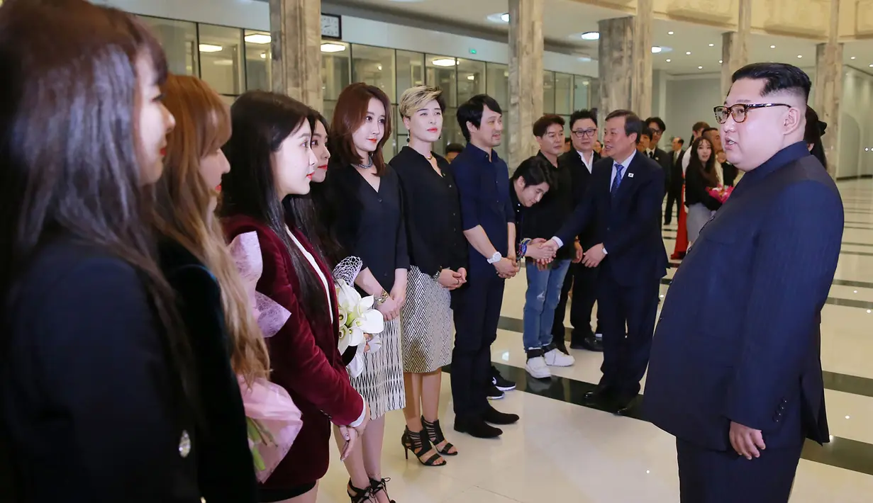 Pemimpin Korea Utara Kim Jong-Un (kanan) berbicara dengan sejumlah bintang K-pop dan musisi dari Korea Selatan di East Pyongyang Grand Theatre, Korea Utara (4/1). (AFP Photo/KCNA)