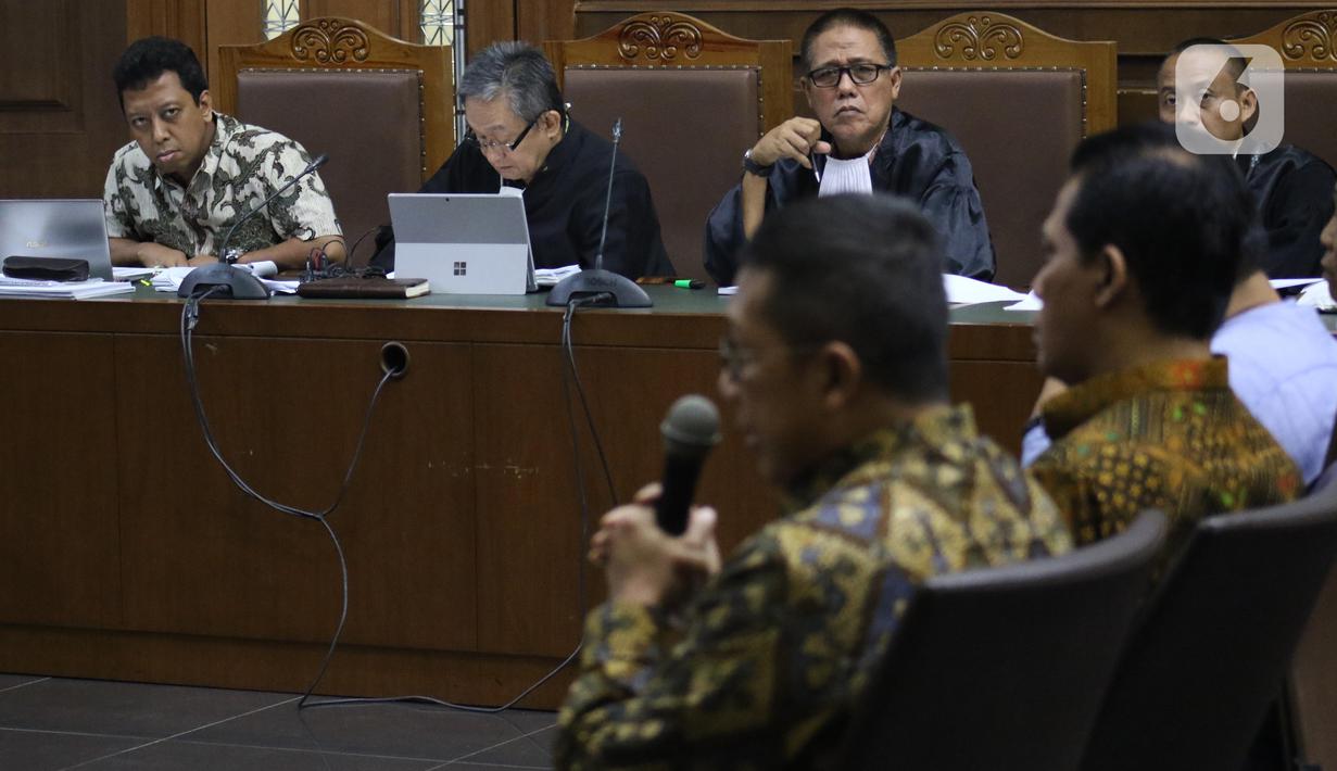 Terdakwa dugaan suap jual-beli jabatan di lingkungan Kemenag, M Romahurmuziy (kiri) menyimak keterangan mantan Menteri Agama, Lukman Hakim Saifuddin saat sidang lanjutan di Pengadilan Tipikor Jakarta, Rabu (4/12/2019). Sidang beragenda mendengar keterangan saksi. (Liputan6.com/Helmi Fithriansyah)