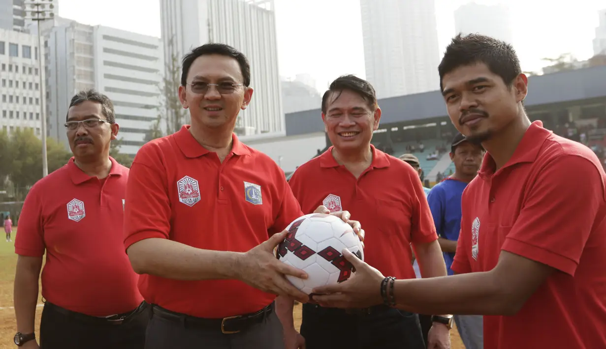 Gubernur DKI Jakarta, Basuki T Purnama menerima bola dari legenda hidup sepak bola Indonesia, Bambang Pamungkas saat membuka turnamen Rusun Cup 2015. (Bola.com/Vitalis Yogi Trisna)