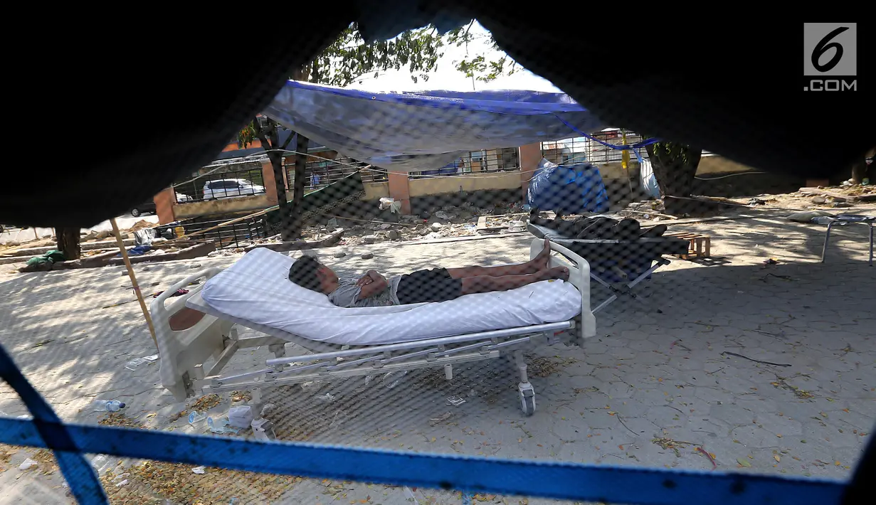 Pasien tertidur di halaman Rumah Sakit Undata, Palu, Sulawesi Tengah, Kamis (4/10). Puluhan pasien korban gempa bumi dan tsunami Palu dirawat dengan kondisi seadanya. (Liputan6.com/Fery Pradolo)