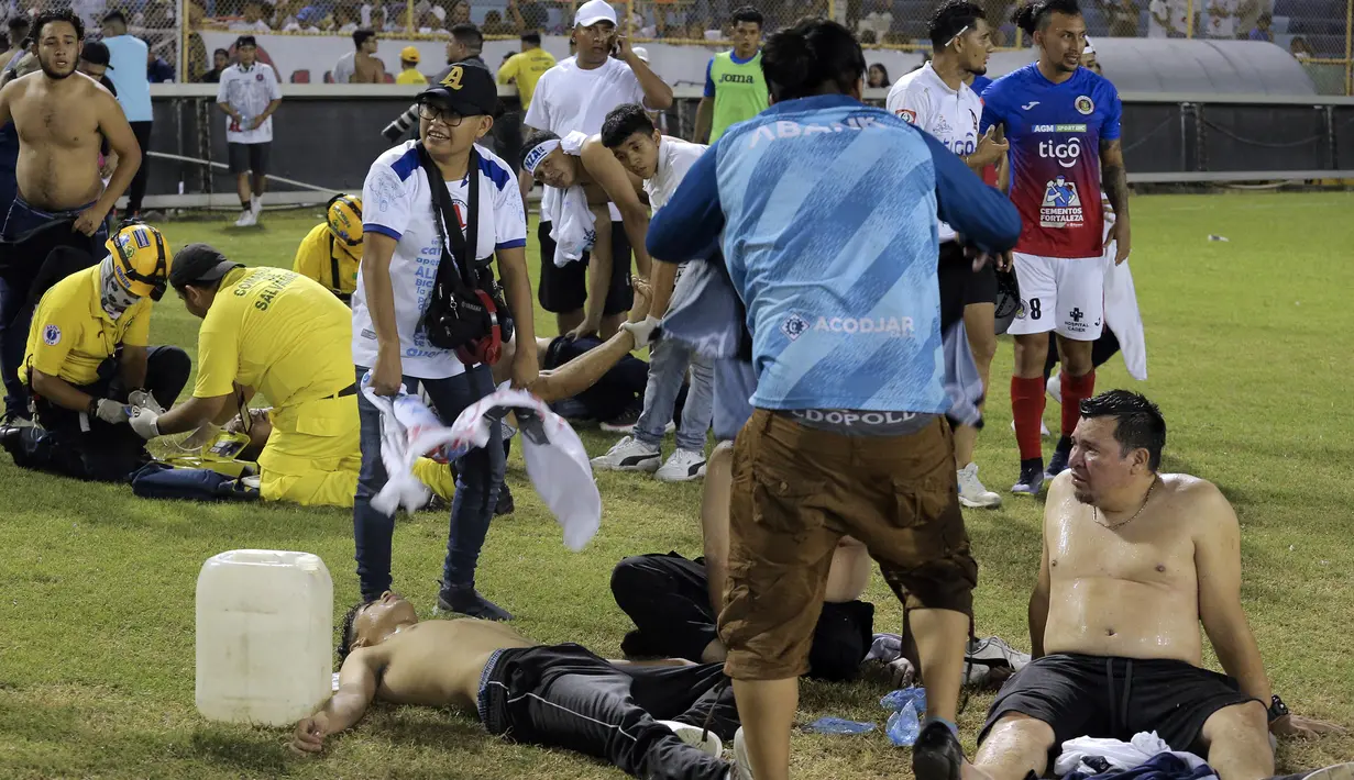 Tim medis dan beberapa sukarelawan tampak memberikan pertolongan kepada beberapa korban saat terjadi kerusuhan suporter akibat saling berebut masuk ke dalam Stadion Monumental, Cuscatlan, San Salvador, El Salvador, Sabtu (21/5/2023) waktu setempat untuk menyaksikan laga perempatfinal Divisi Utama El Salvador antara Alianza FC menghadapi Deportivo FAS. (AFP/Milton Flores)