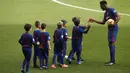 Yerry Mina bersalaman dengan anak-anak saat sesi perkenalan di Camp Nou stadium, Barcelona, (13/1/2018). Mina didatangkan Barcelona dari Palmeiras sebesar 10.5 juta pounds. (AP/Manu Fernandez)