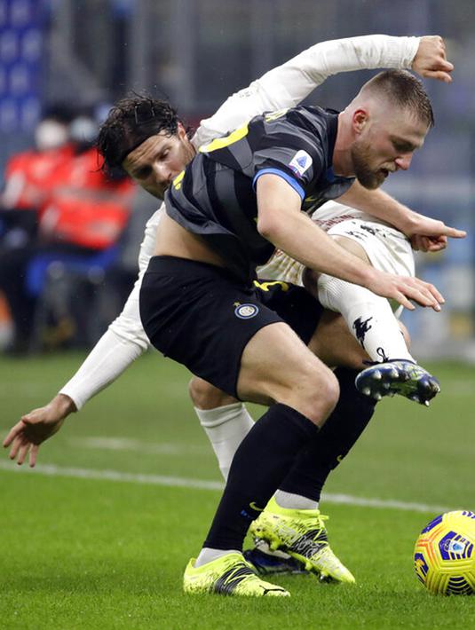 Pemain Inter Milan Skriniar (depan) memperebutkan bola dengan pemain Benevento Gianluca Caprari pada pertandingan Serie A Liga Italia di Stadion San Siro, Milan, Italia, Sabtu (30/1/2021). Inter Milan membantai Benevento 4-0. (AP Photo/Luca Bruno)