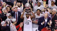 Pebasket Toronto Raptors, Kawhi Leonard, mengangkat trofi usai mengalahkan Milwaukee Bucks pada NBA Final Wilayah Timur di Scotiabank Arena, Toronto, Sabtu (25/5). Raptors menang 4-2 atas Bucks. (AFP/Claus Andersen)