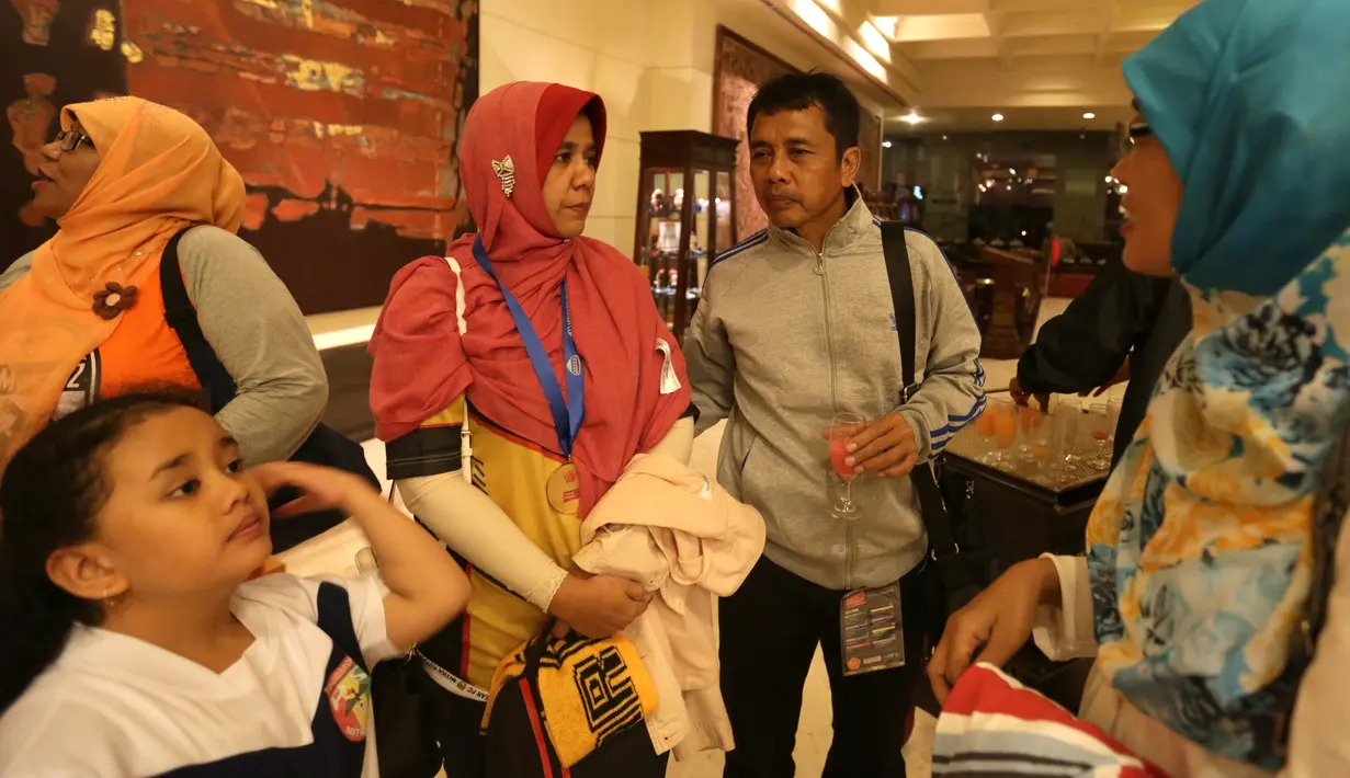 Pelatih Mitra Kukar, Jafri Sastra bersama keluarganya saat tiba di Hotel Sultan, Jakarta, Minggu (24/1/2016) seusai final Piala Jenderal Sudirman. (Bola.com/Arief Bagus)
