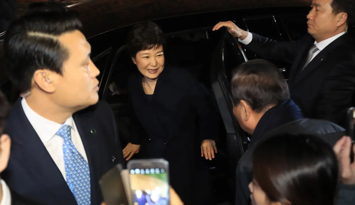 Park Geun-hye turun dari mobil setibanya di rumah pribadinya setelah meninggalkan Blue House di Seoul, Minggu (12/3). Park Geun-Hye telah resmi dimakzulkan dari posisi Presiden Korea Selatan terkait skandal korupsi. (str/YONHAP/AFP)