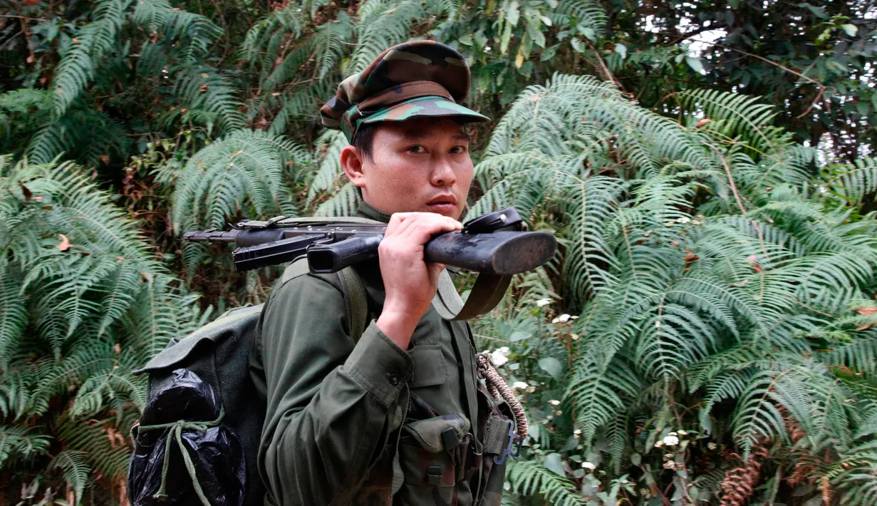 Seorang Tentara Kemerdekaan Kachin berjalan di hutan Mu Du, negara bagian Kachin, Myanmar, 17 Maret 2018. Mayoritas etnis Kachin di Myanmar merupakan penganut agama Kristen. (AP Photo/Esther Htusan)