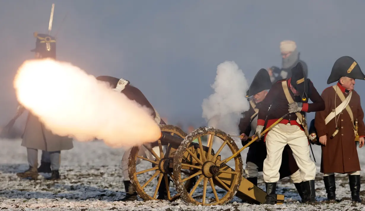 Penggemar sejarah mengenakan kostum tentara menembakan meriam saat melakukan adegan perang Napoleon yang terkenal di Austerlitz, Republik Ceko (2/12). Acara ini untuk memperingati pertempuran Austerlitz ke-212. (AP Photo/Petr David Josek)