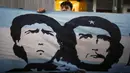 Seorang fans membentangkan bendera bergambar Diego Maradona dan Ernesto "Che" Guevara di depan Rumah Sakit di La Plata, Argentina, Selasa (3/11/2020). Sejumlah fans Argentina berkumpul di depan rumah sakit untuk memberi dukungan kepada sang legenda. (AP/Natacha Pisarenko)