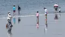 Orang-orang berjalan di pantai Katase-kaigan di Fujisawa, prefektur Kanagawa, dekat Tokyo, Senin (8/6/2020). Jepang mengangkat keadaan darurat coronavirus-nya, mengakhiri pembatasan secara nasional ketika bisnis mulai dibuka kembali. (AP Photo/Koji Sasahara)